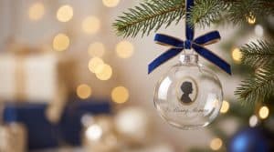 A personalized memorial ornament hanging on a Christmas tree, honoring the memory of a loved one who has passed away